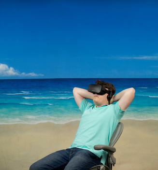 Prodigy, Palmer Luckey wears virtual reality glasses as he sits in a chair with his arms resting behind his head in front of a beach scene