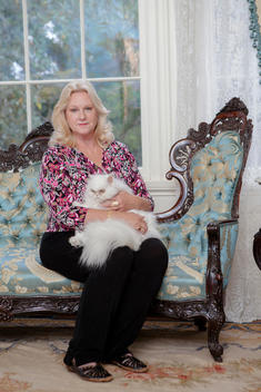Ginger Hyland, present owner of The Towers, poses for a photograph with her cat in one of the many rooms.