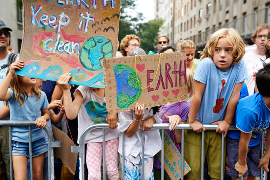 kids holding a banners pro environment at the climate march