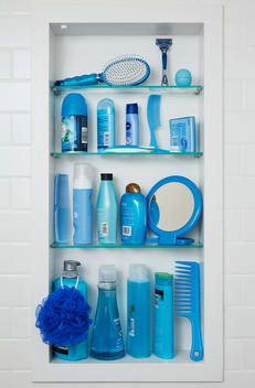 Four bathroom shelves are filled with all blue beauty and hygiene products