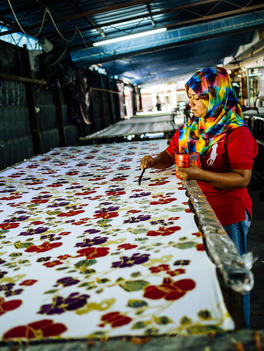 A woman hand paints the batik at a batik factory in Teluk Bahang in Penang, Malaysia.