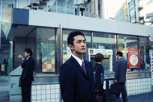 Young Man Standing Along Street In Tokyo, Japan.