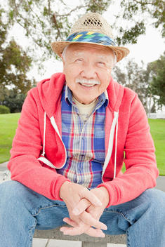 Older Asian man smiling outdoors