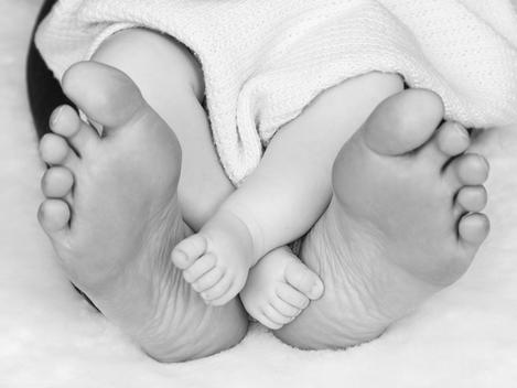 Mother and new born baby\'s feet.