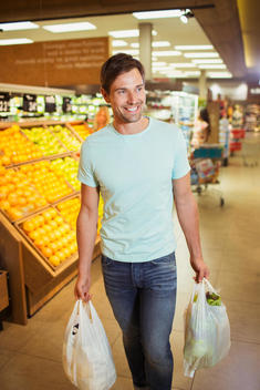 Man carrying shopping bags in grocery store