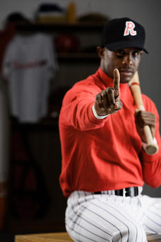 African baseball player making number one gesture in locker room
