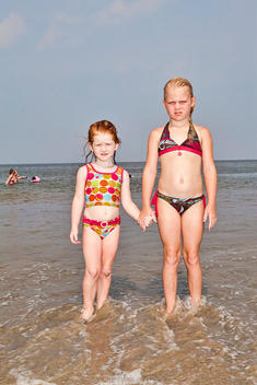 Portrait Of Two Girls Holding Hands At The Beach, Tybee Island, Georgia, Usa.