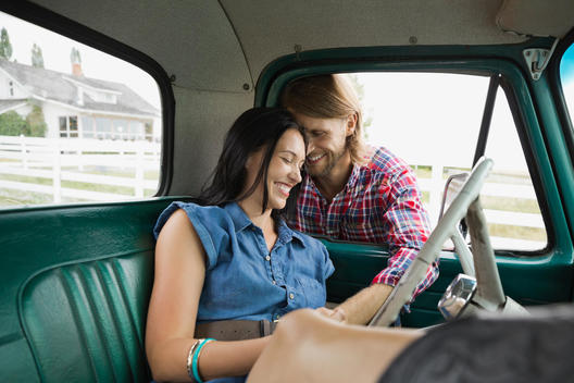 Affectionate couple in vintage pick-up truck