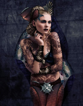 Fashion Shot Of Woman Dressed In Regal Clothing And Headdress With Intricate Patterns Layered Onto Skin.
