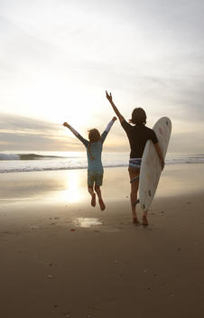 Mother and daughter say goodbye to sun after surfing.