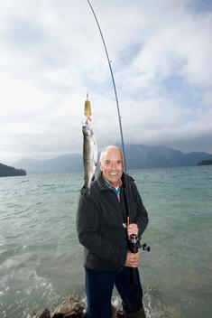 Germany, Bavaria, Walchensee, Senior man fishing in lake