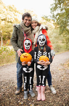Parents smiling with children in skeleton costumes
