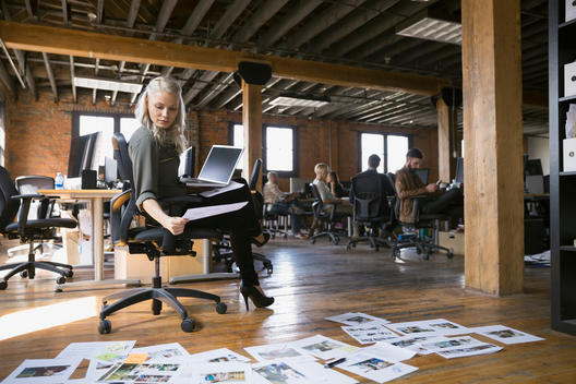 Businesswoman reviewing proofs in office