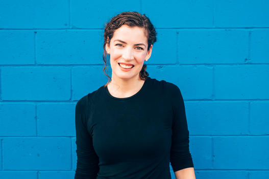 Woman standing in front of blue wall.
