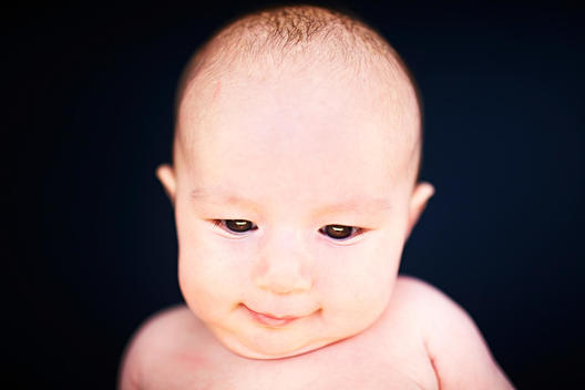 Portrait of baby boy against black background