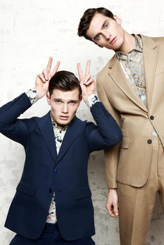Two boys pulling faces in blue and gold suits.