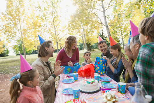 Happy multi-generation family celebrating girls birthday in park