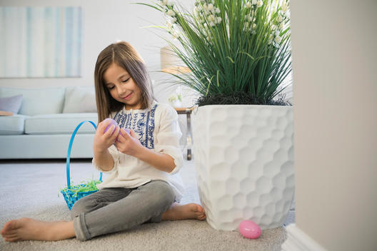 Girl collecting Easter eggs at home
