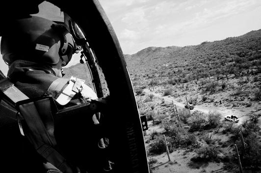 Tohno O'odham Indian Reservation, Arizona USA August 24, 2007 Army National Guard helicopter pilot Major George Harris and another National Guard pilot spot two vehicles hidden in trees along a road that cuts illegally through an Indian reservation on wha