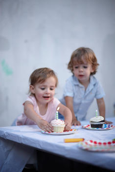 A picture of a little girl about to enjoy a birthday cupcake.