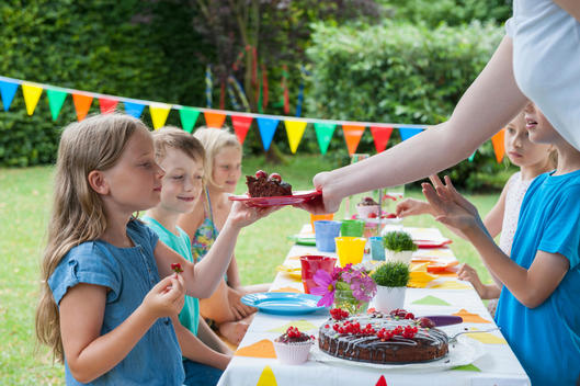 Girl receiving piece of cake on a birthday party