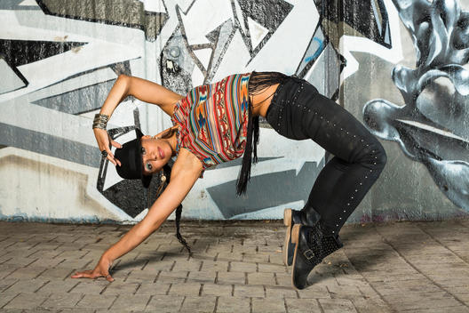 Female hip hop dancer dancing in front of airbrushed wall