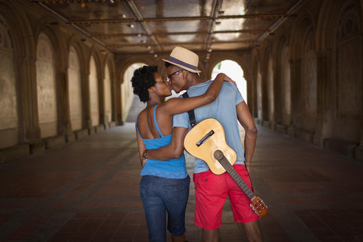 Rear view of young couple with mandolin in Bethesda Terrace arcade, Central Park, New York City, USA