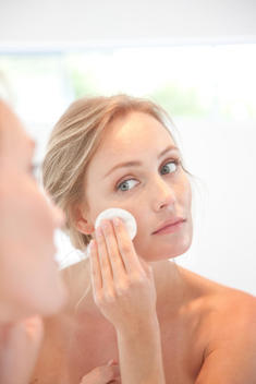 Woman Using Cleansing Cotton Pad on Face