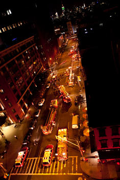 Vertical aerial view of a fire being tended to by the fire department in the city.