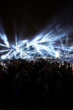 A wide shot of a rave with an impressive light show.