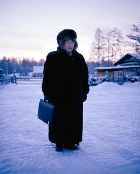 A Yakut Women Wearing A Fur Coat And Hat, Carrying A Brief Case.