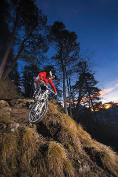 Female mountain biker riding down steep mountain track