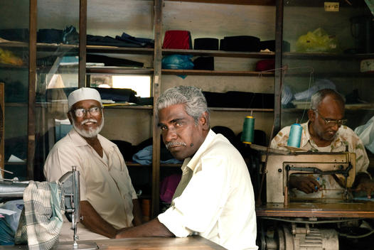 Three Indian Tailors At Work In Their Workshop In Little India
