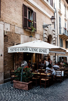 Mimi E Coco Wine Bar on a stone-paved street in Rome, Italy.