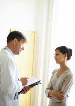 Doctor and woman talking in hospital corridor