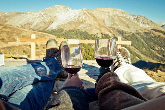 Holding red wine while looking into the mountains