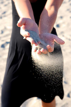 Woman Letting Sand Fly In Wind