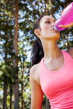Female jogger drinking from water bottle