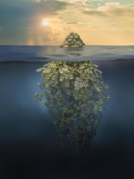 Iceberg of money floating in ocean