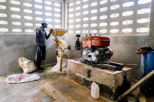A survivor of the 2010 earthquake in La Gonave, Haiti works at a grain mill set up by World Vision in the wake of the tragedy to employ and feed survivors.