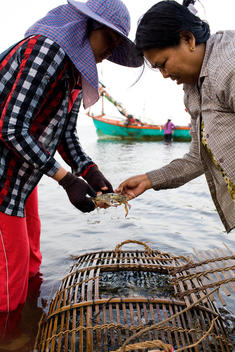Two Women Standing In Ocean Holding Crab