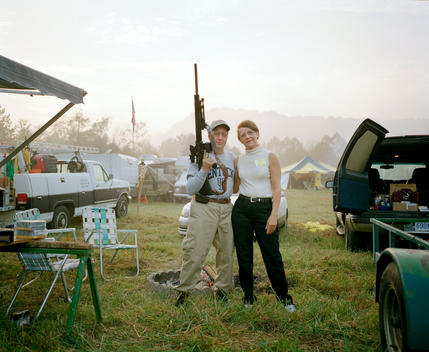 Couple posing with a gun.