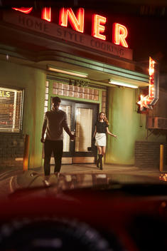man and woman walking out of a diner