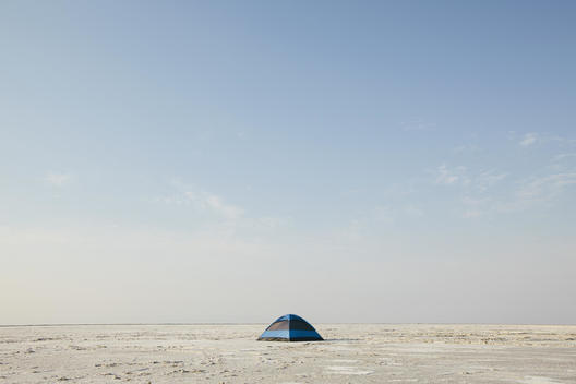 A blue tent on Bonneville Salt Flats at dusk.