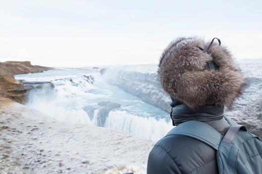 Woman taking in view, Gullfoss Waterfall, located in the canyon of Hvita River in South West Iceland
