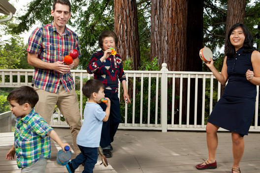 A multicultural family of 5 play with toy instruments on their deck