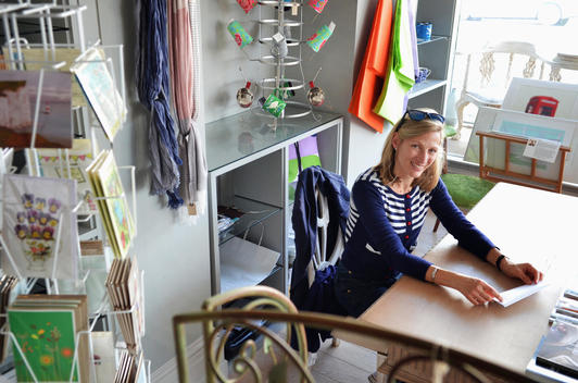 Portrait of mature female shop keeper sitting at desk