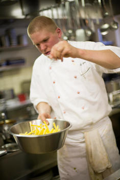 a chef salting French fries in the kitchen of the restaurant on top of Weissfluhgipfel on Parsenn mountain