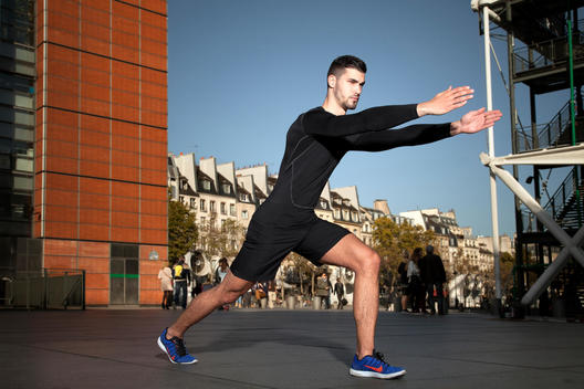 Athletic man stretching in urban setting
