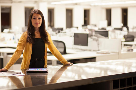 Mixed race businesswoman using digital tablet in office